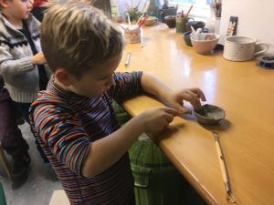 dítě při tvoření z keramiky